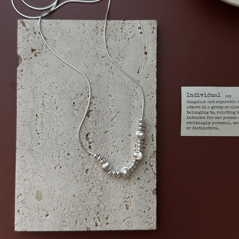 S925 Sterling Silver Snake Chain Necklace with Brushed Bead Cluster on Travertine Slab