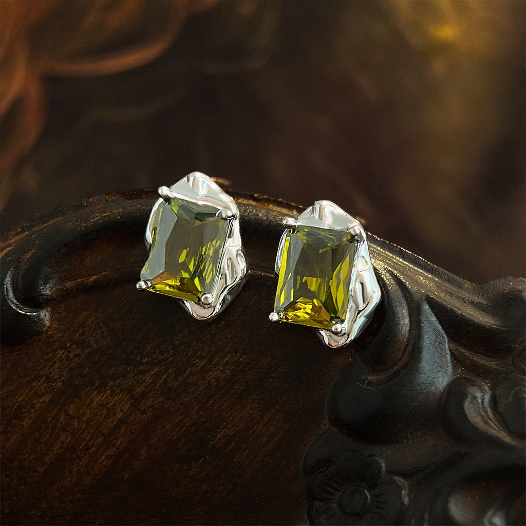 Molten fluid silver liquid metal frame with emerald cut peridot studs