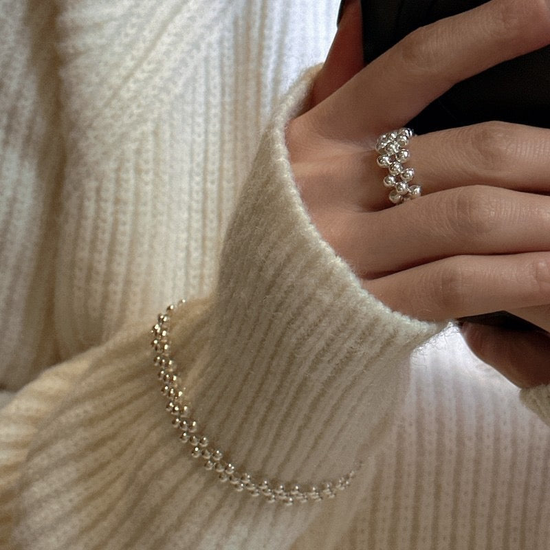 S925 sterling silver triple-row woven bead bracelet displayed on French Paris linen cushion