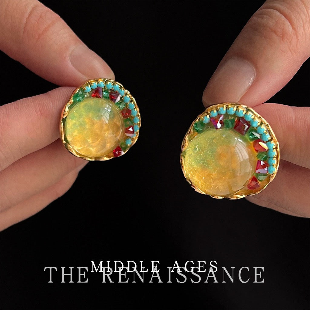 Pair of Sunlit Garden textured gold and glass earrings held in hand