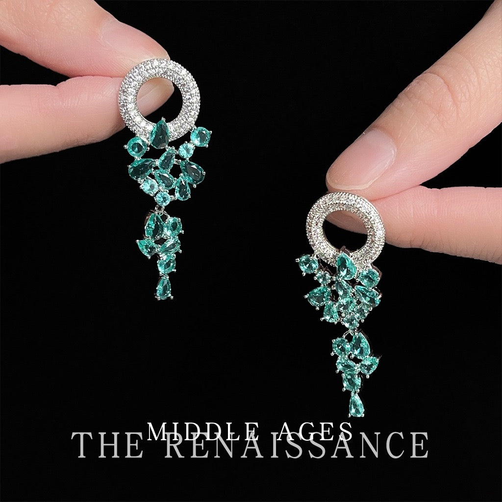 Pair of articulated green crystal waterfall dangle earrings held in hand
