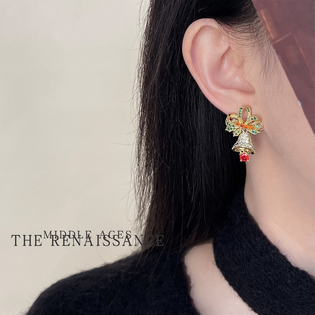 Model wearing festive Christmas bow and bell drop earrings